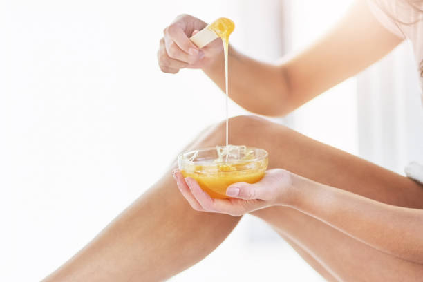 Closeup shot of an unrecognizable woman waxing her legs in the bathroom at home